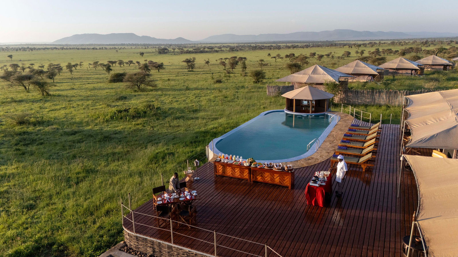 Swimming pool and sun deck looking out over the open Serengeti plains at Arukore Simba Camp