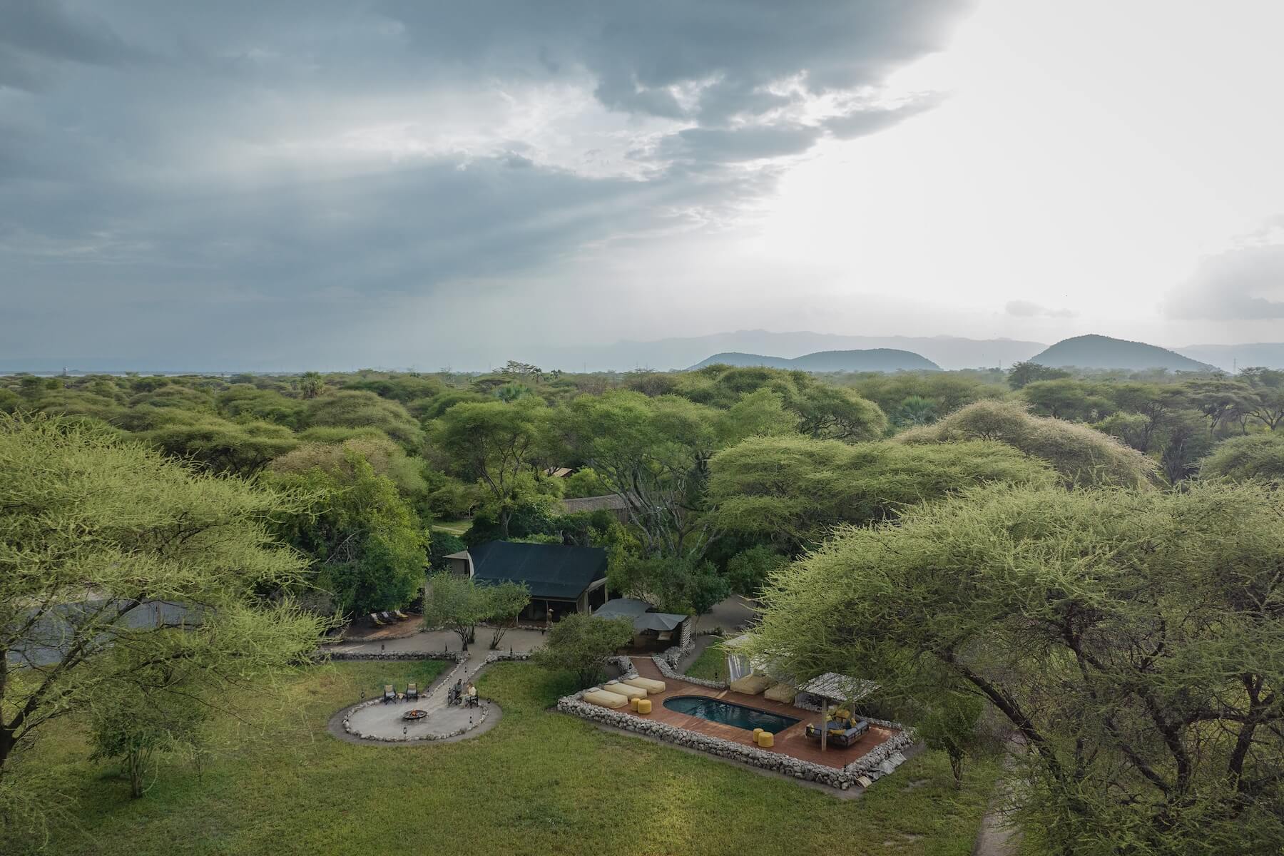 Aerial view of Forest Chem Chem, its few tents, fire circle and pool set in acacia woodland