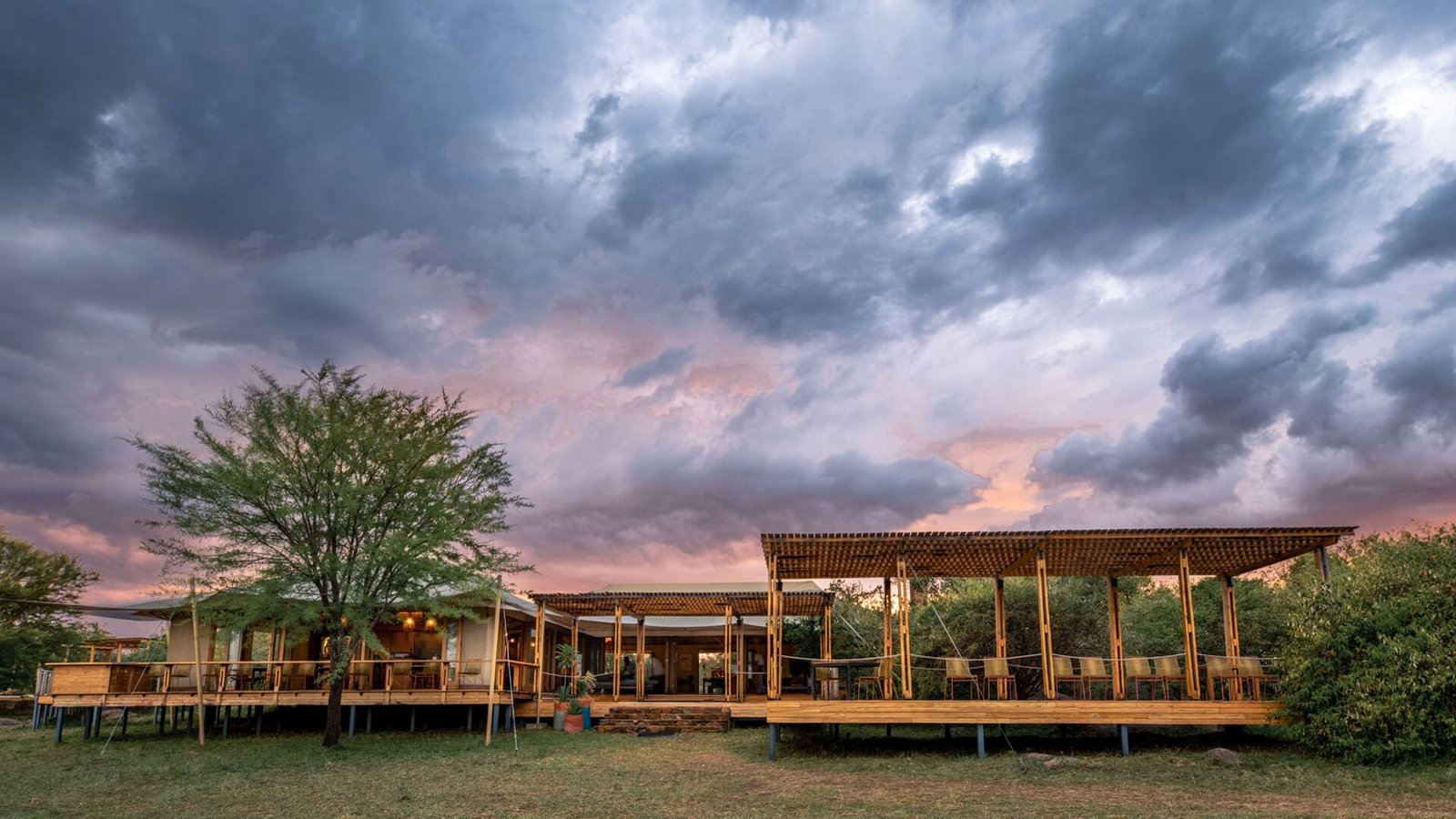 Sayari Camp main area and decks at dusk under storm clouds
