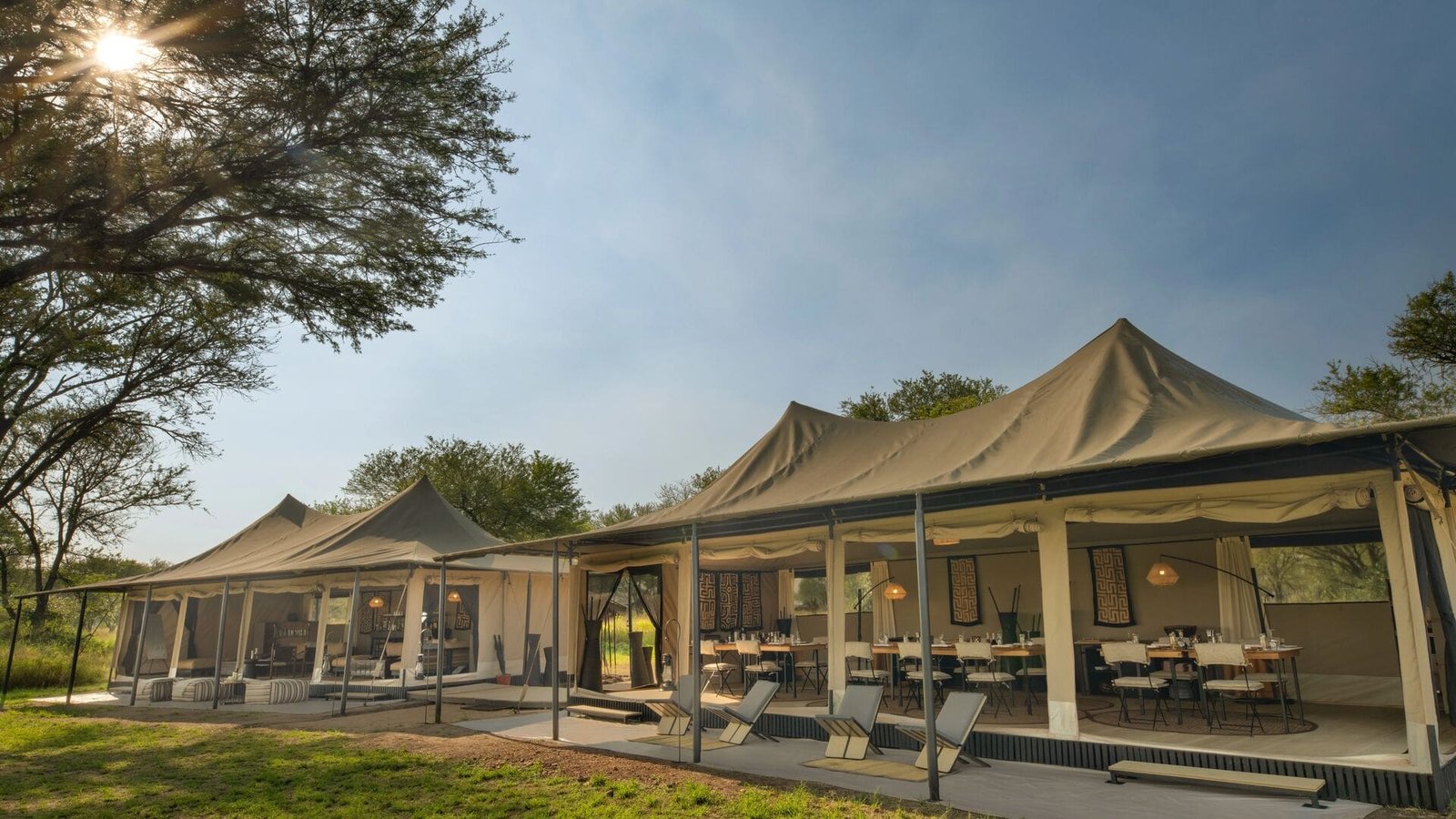 Two canvas mess tents with open sides and a shaded deck at Ubuntu Migration Camp